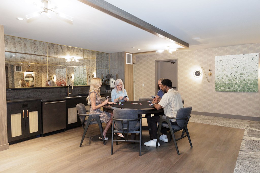 Four people sitting around a table in a modern kitchen.