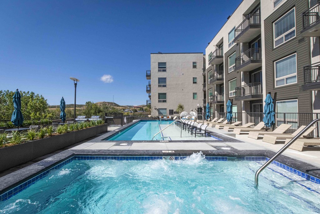 a swimming pool with an apartment building in the background