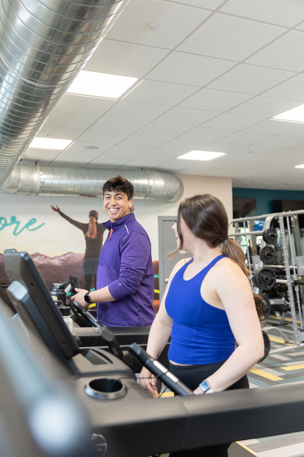 a man and a woman on a treadmill in a gym