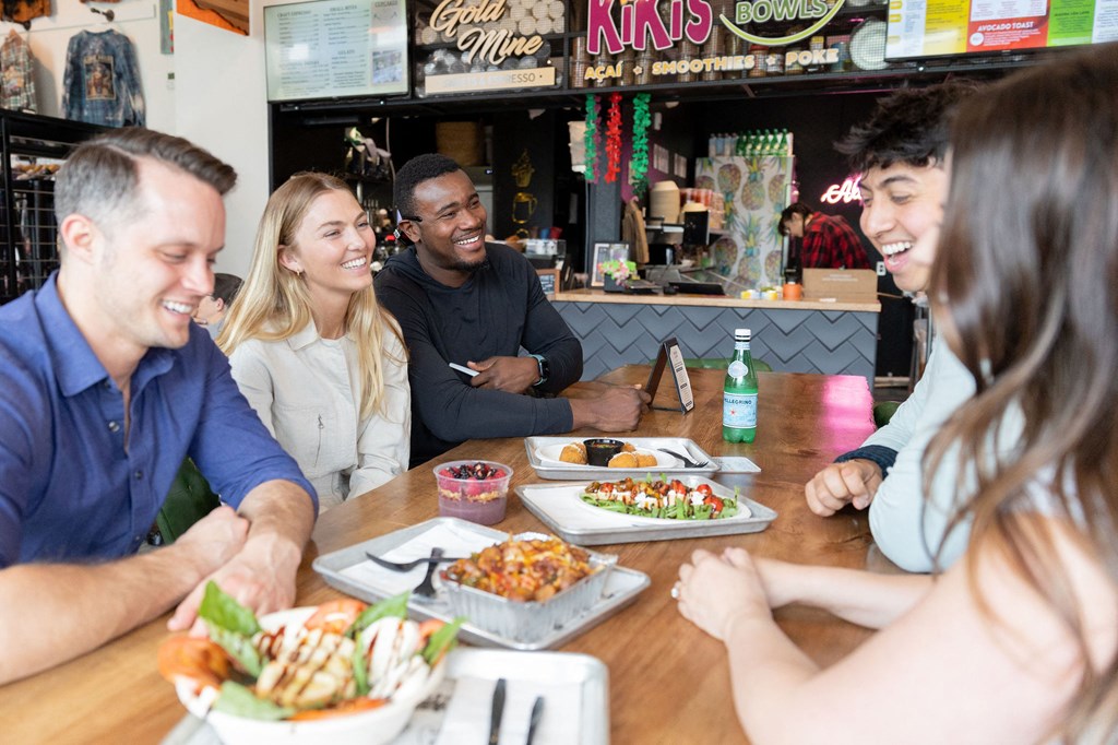 a group of people sitting around a table eating food