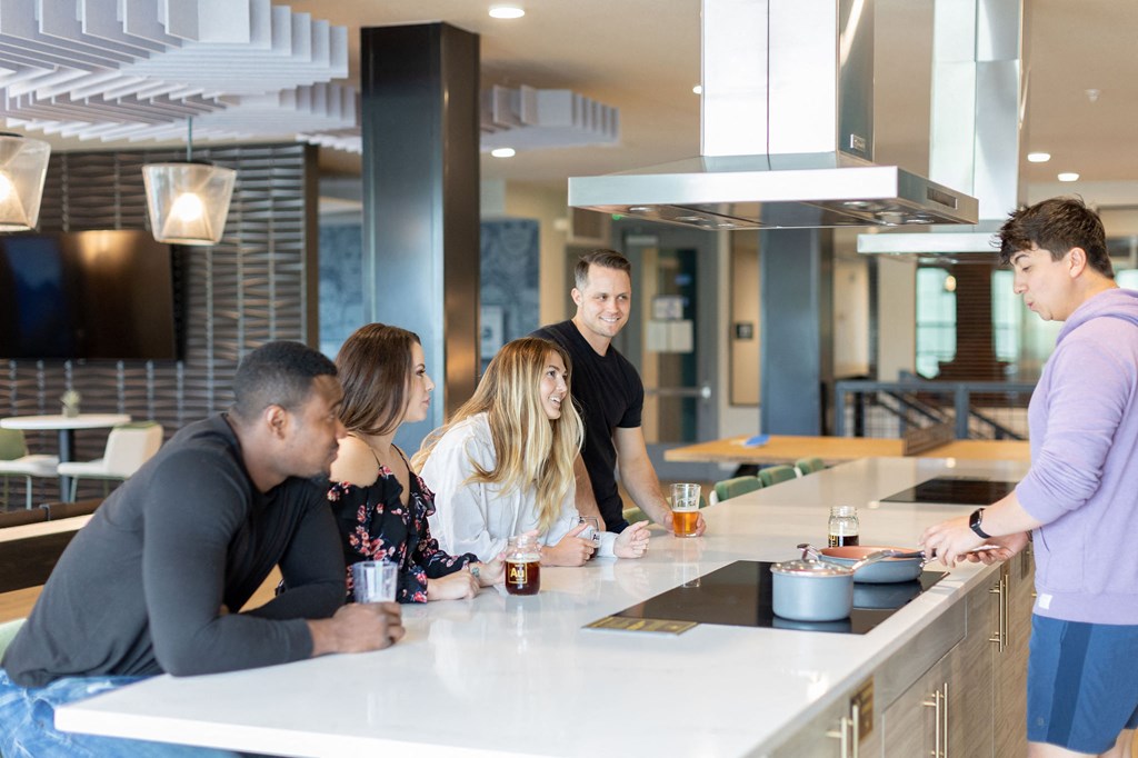 a group of people standing around a counter in a restaurant