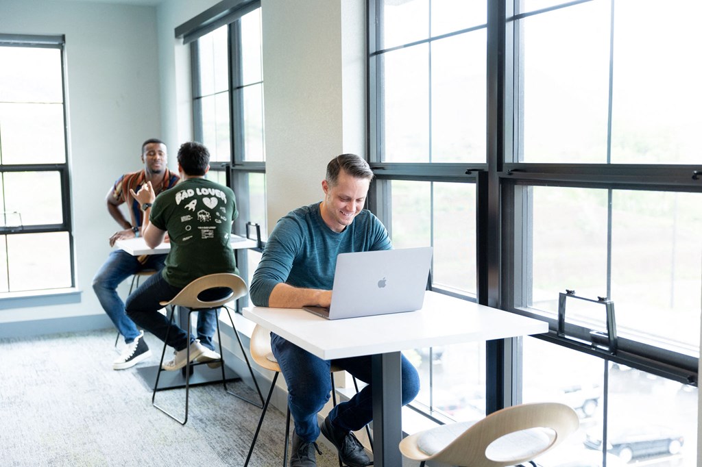 a man sitting at a table with a laptop