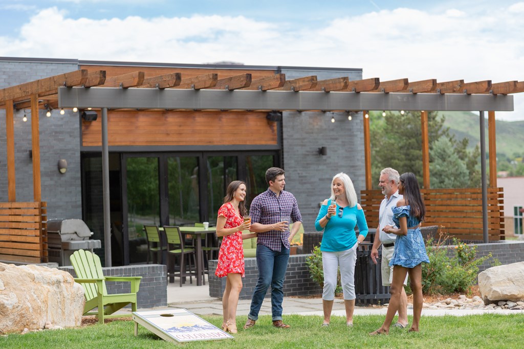 a group of people standing on a lawn in front of a house