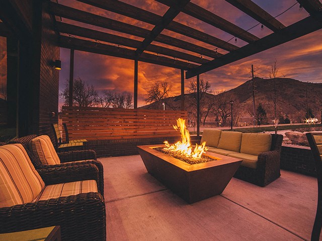 a patio with couches and a fire pit