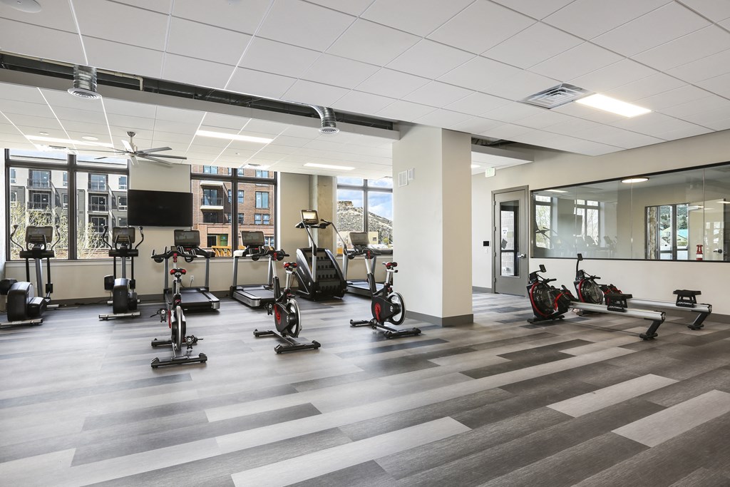 a fitness room with treadmills and other exercise equipment in a building