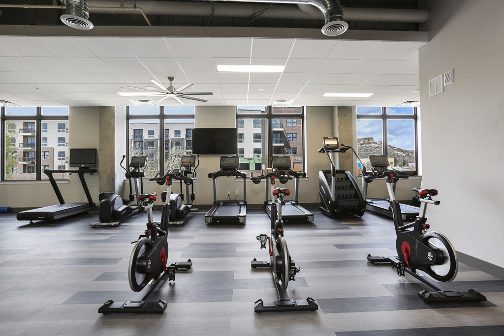a fitness room with treadmills and other exercise equipment