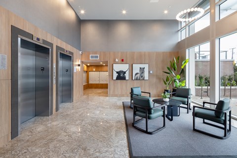 A spacious waiting area with two elevators and a seating area.