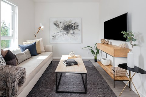 A living room with a white couch, a coffee table, and a large painting on the wall.