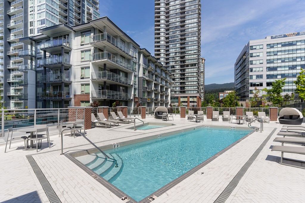 A large swimming pool in front of apartment buildings.
