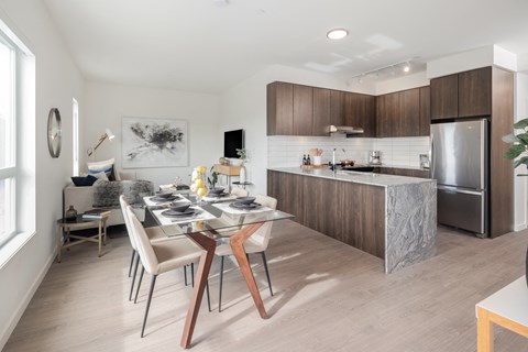 A modern kitchen with a dining table set for two.