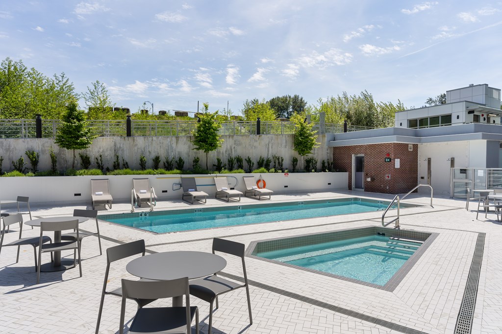 A pool with a table and chairs around it.