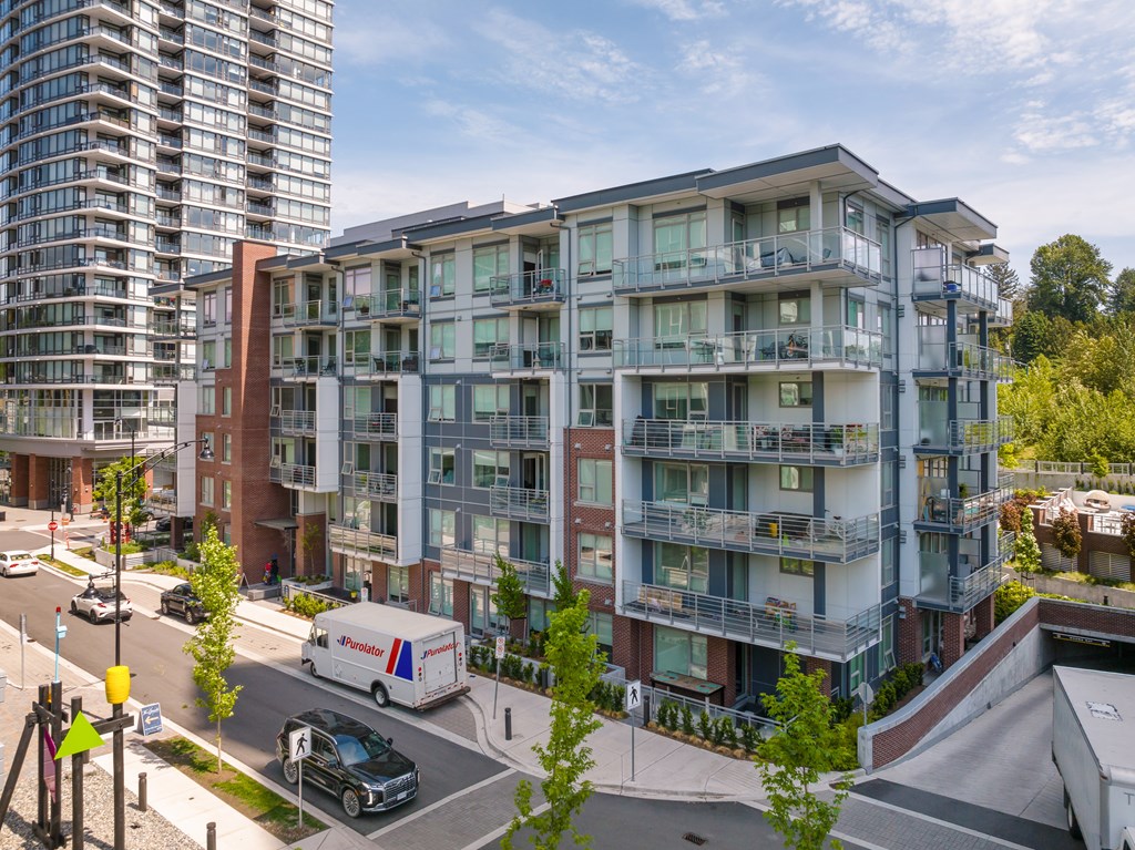 A white van is parked on the street in front of a building.