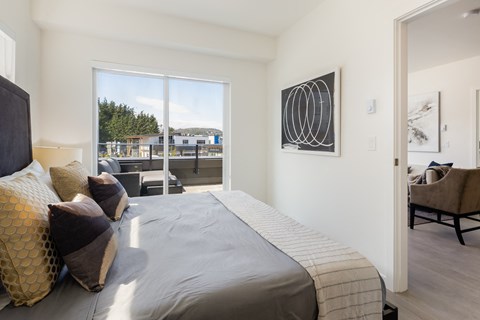 a bedroom with a large bed and a door to a balcony