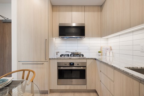 A modern kitchen with a stove top oven and microwave.