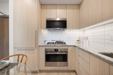 A modern kitchen with a stove top oven and microwave.