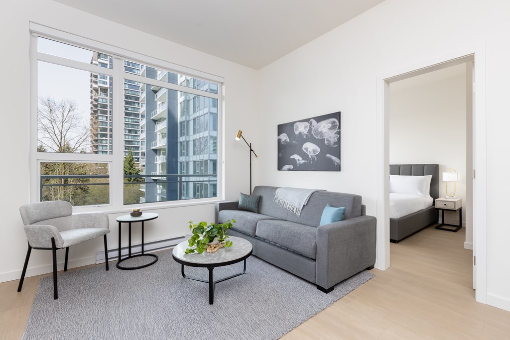 A grey couch with a white throw is in the living room.