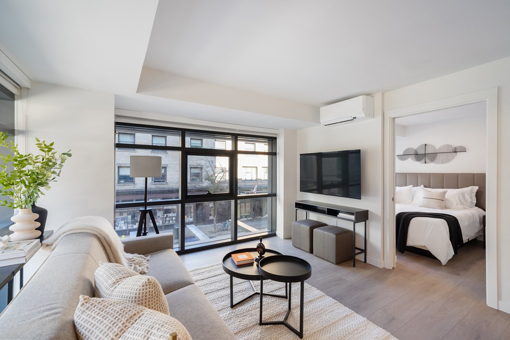 A living room with a grey couch and a black coffee table.