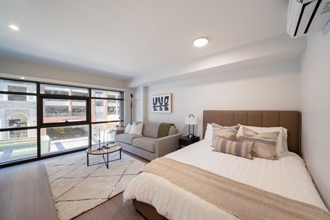 A bedroom with a large bed and a view of the street outside.