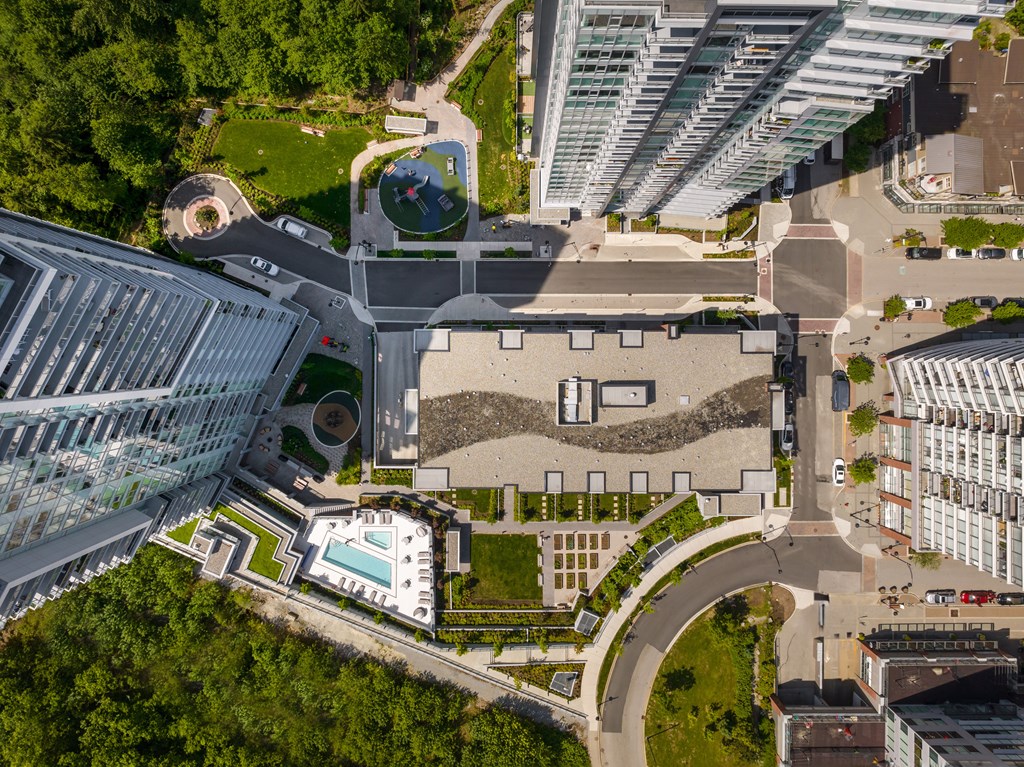 A modern building with a glass facade and a circular courtyard with a fountain.