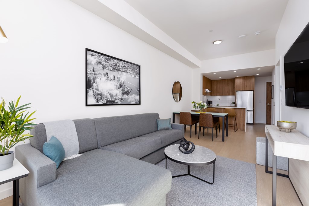 A modern living room with a grey couch and a coffee table.
