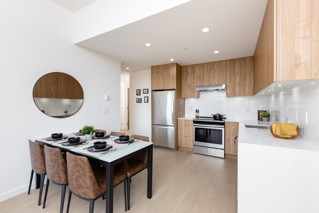 A modern kitchen with a dining table and chairs.