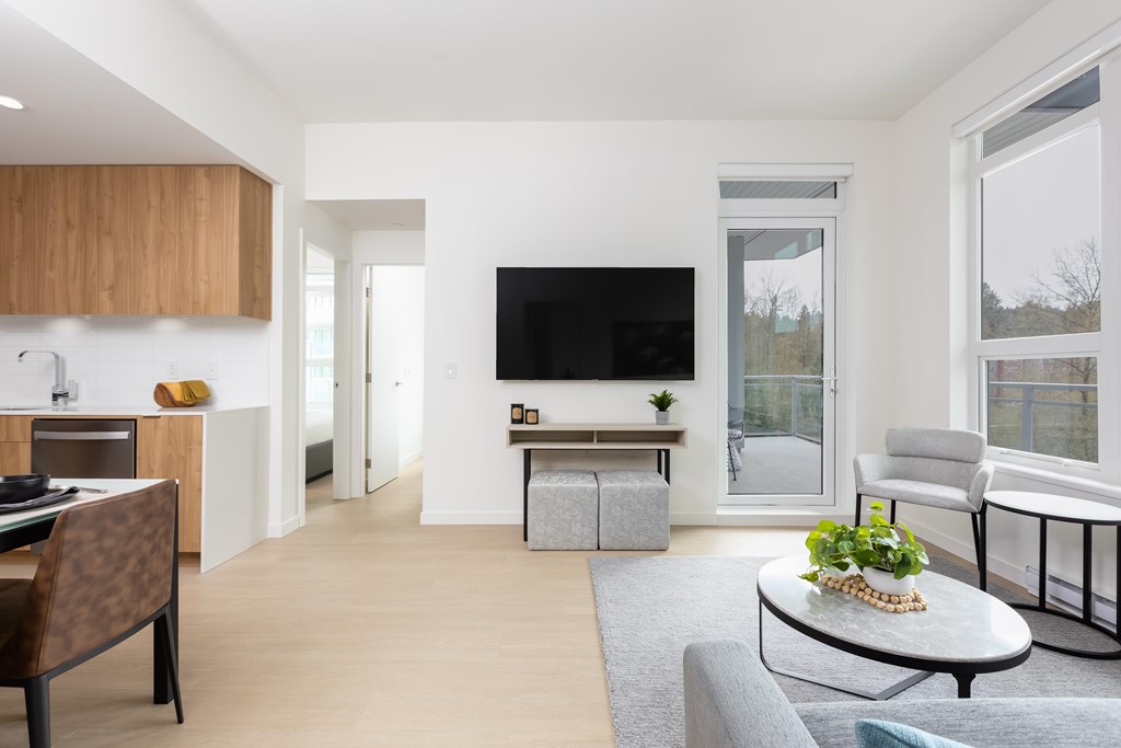 A modern living room with a flat screen TV and a grey sofa.