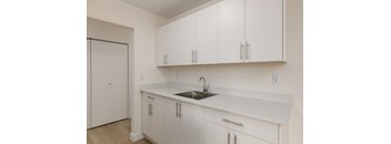 A kitchen with white cabinets and a sink.