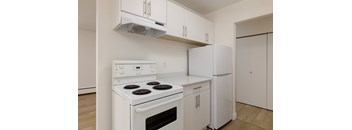 A white stove and refrigerator in a kitchen.