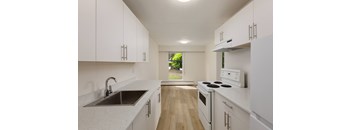 A kitchen with white cabinets and a stove top oven.