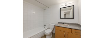 A white toilet sits next to a white bathtub in a bathroom.