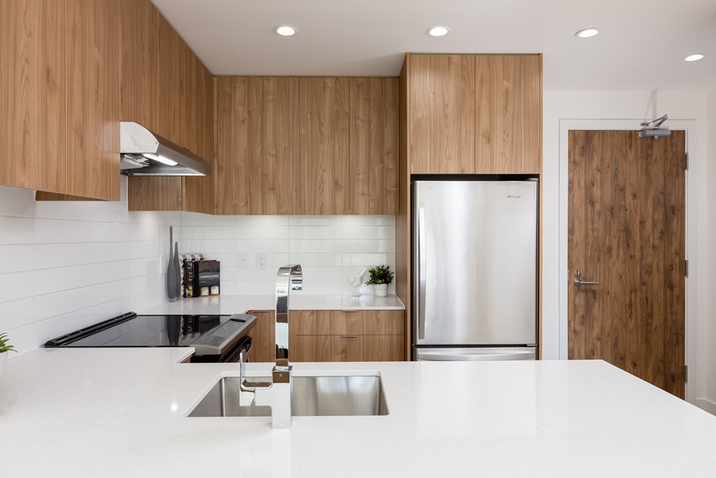 A modern kitchen with wooden cabinets and stainless steel appliances.