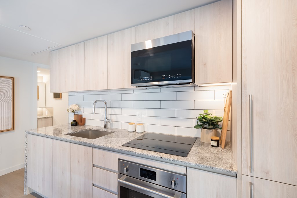 A modern kitchen with a stainless steel sink and oven.