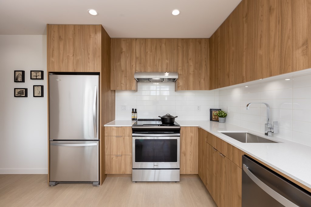 A modern kitchen with wooden cabinets and stainless steel appliances.