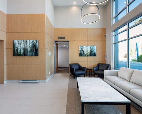 A modern living room with a white couch, a coffee table, and two paintings on the wall.