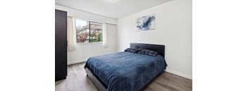 A bedroom with a blue bedspread and a black headboard.