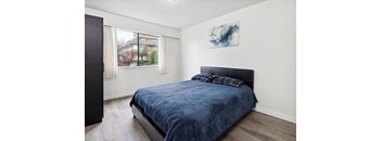 A bedroom with a blue bedspread and a black headboard.