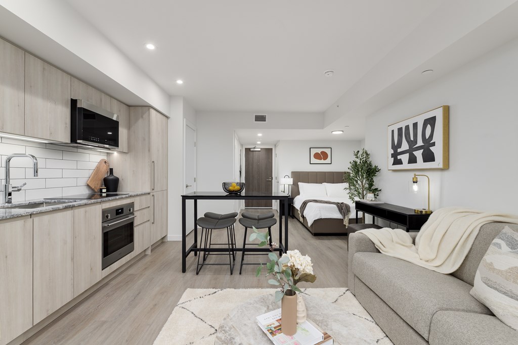 A modern kitchen with a dining area and a living room.