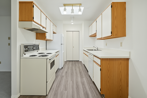A kitchen with wooden cabinets and a white counter.