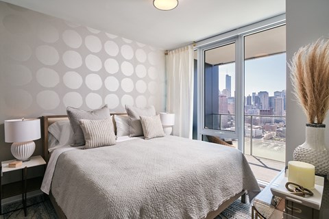 A bedroom with a large bed and a view of the city.