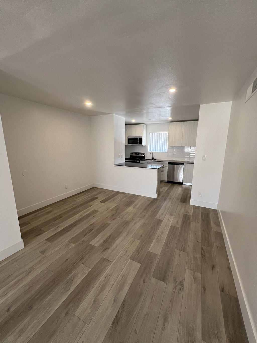 an empty living room and kitchen in an apartment