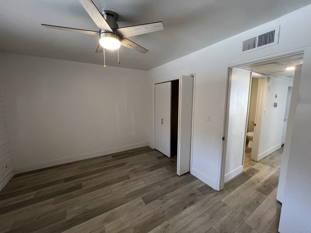 a living room with wood flooring and a ceiling fan