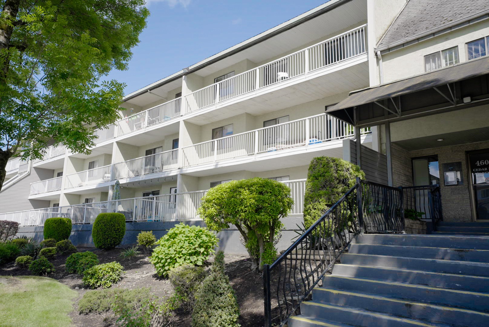 A building with a balcony and stairs leading to the entrance.
