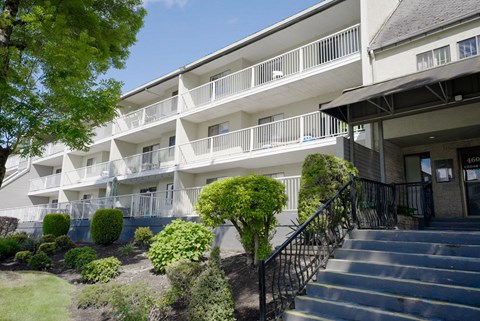 A building with a white facade and a black railing.