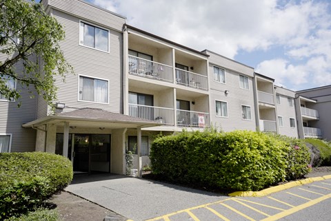 Apartment building with a parking lot in front.