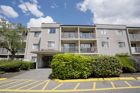 Apartment building with a yellow parking lot in front.