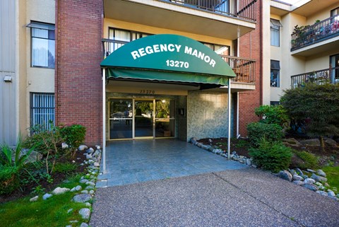 The front of the Regency Manor building with a green awning.