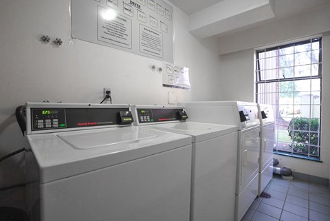 A laundry room with washers and dryers and a sign on the wall.