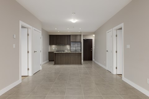 A spacious kitchen with white cabinets and a dark countertop.