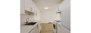 A kitchen with white cabinets and a stove top oven.