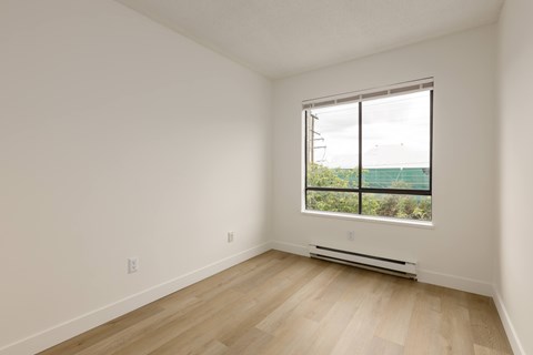 A room with a window and a radiator on the floor.